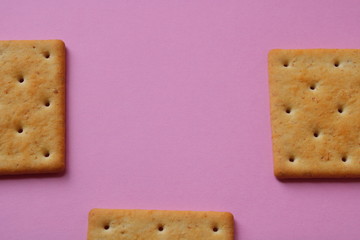 square cracker on a pink background