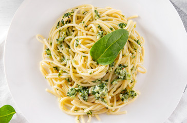 pasta with spinach and cheese on a white plate close up,
