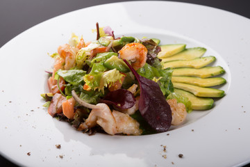 Avocado and shrimp salad in a white bowl plate