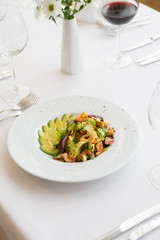Avocado and shrimp salad in a white bowl plate