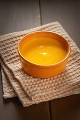  Roasted pumpkin and carrot soup with cream  on a table. Copy space