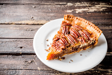 Homemade autumn pecan pie on wooden rustic background, Traditional fall and winter, thanksgiving american nut cake,