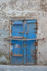 Fototapeta na wymiar Vintage locked wooden blue door at fishing village Essaouira .