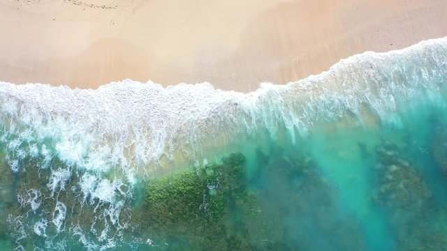 Beach scene - turquoise transparent ocean and  white sand beach. Bali, Dreamland beach, aerial 4k footage.