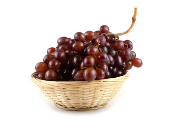 Brown grape on wicker plate