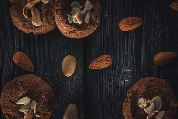 delicious and crunchy cookies with almond and chocolate on dark wooden background