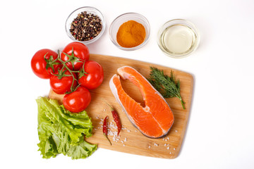 salmon steak with vegetables and spices on a white background. The concept of cooking. Grocery background.Salmon steak, raw fish cooked for cooking. Top view	