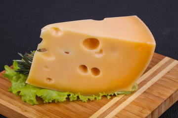 Maasdam cheese  in the board served salad leaves