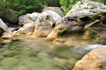 Naklejka na ściany i meble water flowing over rocks