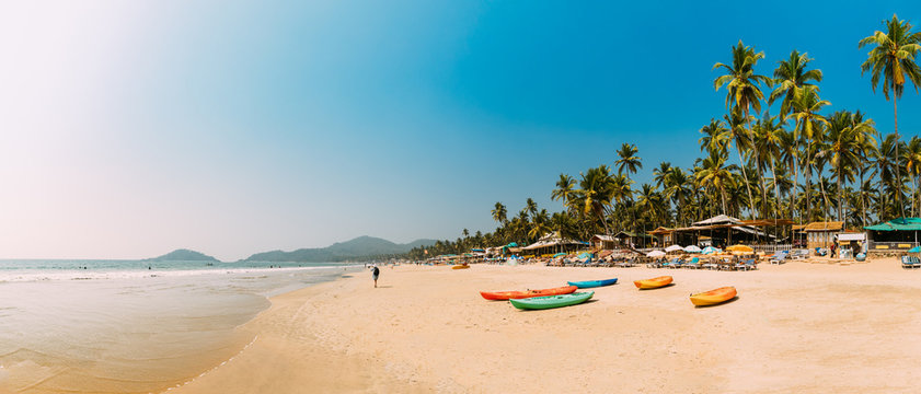 Canacona, Goa, India. Canoe Kayak For Rent Parked On Famous Palolem Beach On Background Tall Palm Tree In Summer Sunny Day