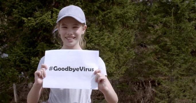 great footage of the victory over a virus. happy girl in a cap with the inscription on the poster in her hands - #Goodbyevirus. a bee flies at the child's face. great joy after the pandemic, 2019-nCoV