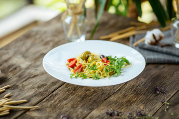 Italian spaghetti pasta with olives and tomatoes