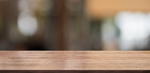 Empty wooden table top with lights bokeh on blur restaurant background.