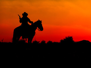Western cowboys are sitting on horseback under the sun and preparing to use guns to protect themselves in a land that is not yet legal