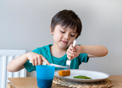 Portrait Of 5 Year Old Kid Boy Having Homemade Fish Finger And French Fries For Sunday Dinner At Home, A Happy Child Eating Lunch, Children Eating Heathy And Fresh Food, Healthy Life Style Concept