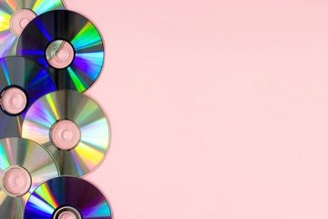 Music cd's dvd's flat lay on pink background top view with copy space. Creative design 80-s style. Recording and listening music, radio, dj concept. Web banner template. Stock photo.