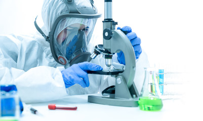 The doctor or scientist is examining the virus or bacteria in the blood with a microscope.