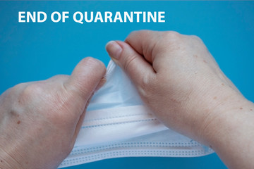 The end of Coronavirus COVID 19 Pandemic. Back to normal life. Woman holding used medical mask, symbol the end of quarantine isolation and beginning of normal life again. 