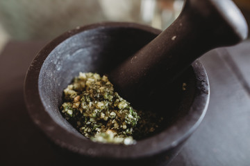 Making homemade basil pesto with pestle and mortar