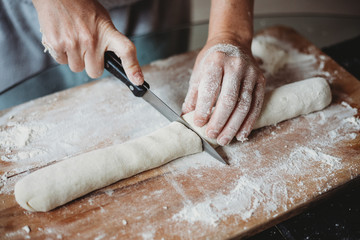 Woman cutting dough to make gnocchi 