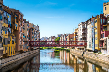 Fototapeta na wymiar Colorful houses and Eiffel bridge over Onya river in Girona, Spain