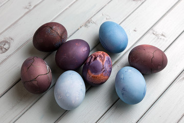 Colored Easter eggs on a light wooden table. Chicken eggs are painted for the Easter holiday.