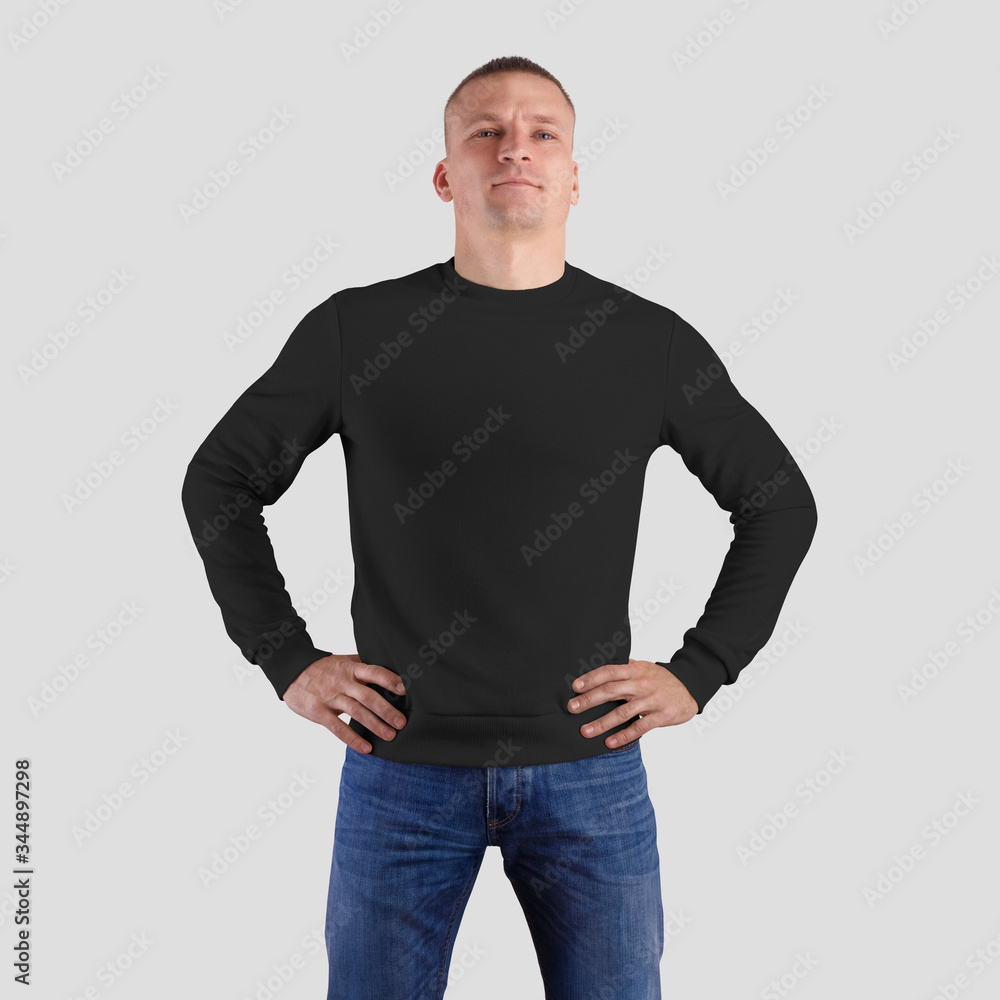 Wall mural Mockup of black sweatshirt isolated on a white background, presentation of a blank heather on a sporty man in jeans.