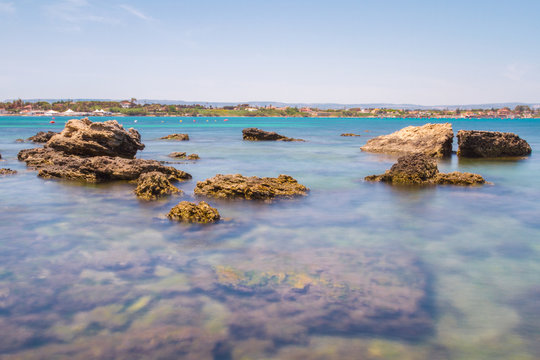 Panorama of the wild nature, blue crystal water of Mediterranean sea and rocky coastline at sunset in province Syracuse in Sicily