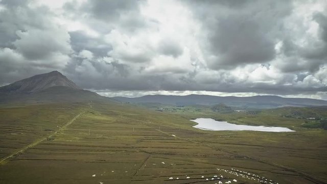 Aerial of moody clouds over a green valley and lake.  Donegal, Ireland.