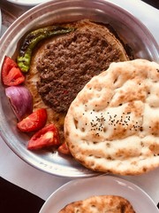 Famous dish Tray Kebab served with onions, pepper and tomatoes