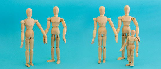 Five mannequins of wooden men. Concept - two different families, one with a child and two without, standing on a blue background.