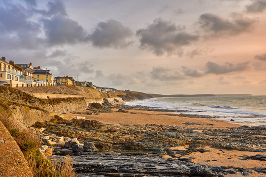 Image of the beach at Porthleven, Cornwall with rocks, cottages, waves and cloudy sky