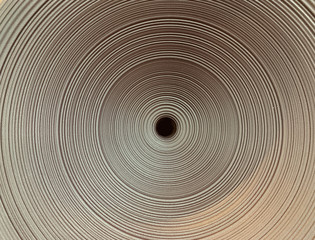 Fototapeta na wymiar Abstraction: the funnel of circles. Ceramic in the form of a spiral. Black hole, narrowing.