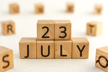 July 23 - from wooden blocks with letters, important date concept, white background random letters around