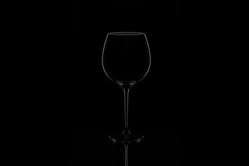 outline of an empty wine glass on a black isolated background