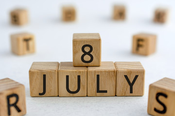 July 8 - from wooden blocks with letters, important date concept, white background random letters...