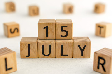 July 15 - from wooden blocks with letters, important date concept, white background random letters...