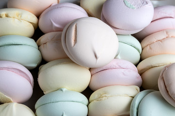 Colored sweet dessert marshmallows on a wooden colored background. Air marshmallows. Confectionery. Background of sweet marshmallow cookies.