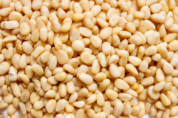 Peeled dried pine nuts background.