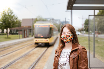 Frau mit Maske an Haltestelle