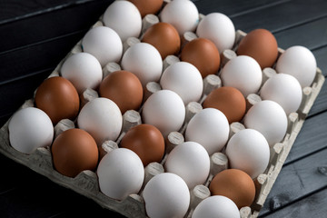 chicken eggs in a cardboard egg tray. White and brown eggs in one tray. The farm's products. Natural egg protein to the diet.