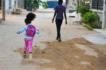 Dakar, Senegal, Africa, February, 2020: Senegalese girl with curly hair, ready to go to school in...