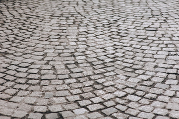 The dark gray paving stones laid out in a semicircle. The texture of the old granite stone. Road surface. Vintage and grunge.