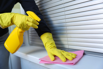 cleaner's hands in rubber gloves doing disinfection cleaning with detergent spray and rag. preventive measures against virus infection