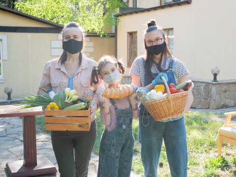 A Woman With Two Daughters With Food Packages For The Socially Vulnerable Segments Of The Population.