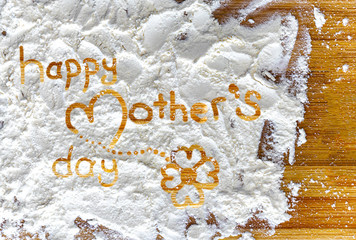 close up happy mother's day letter with flower on flour and wooden chopping board