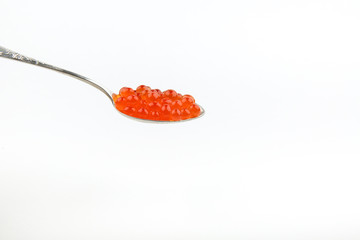 red caviar on a spoon on a white background