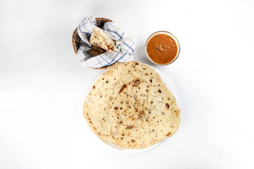 Paper thin rumali roit wheat chapati bread on white plate best served with dal tadka makhana