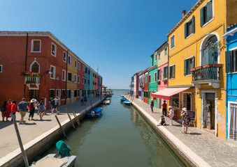 Burano, italian island next to the italian city of Venice, with colorful houses on the border of a canal that leads to the sea in the Laguna di Venezia.