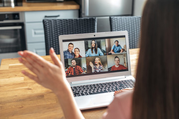 Video call, zoom. Icons of a group of people on laptop screen, app for video online communication. A woman is waving hello in webcam, back view